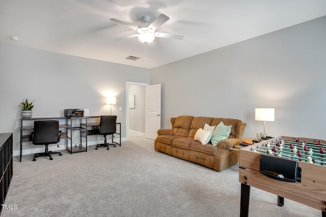 carpeted home office featuring ceiling fan