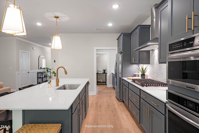 kitchen with stainless steel appliances, pendant lighting, a sink, and a kitchen breakfast bar