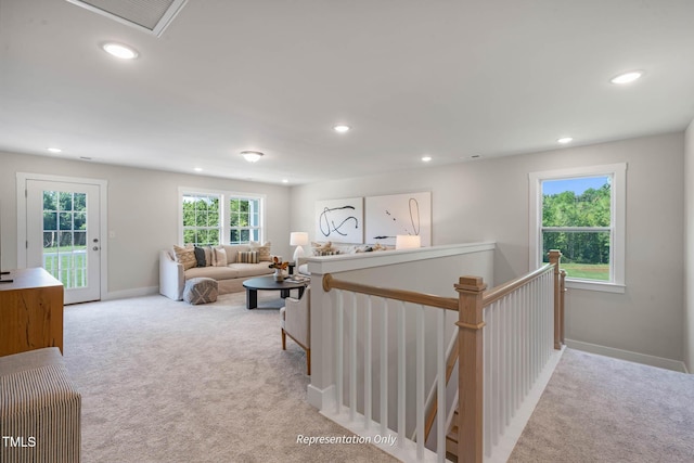 living room featuring recessed lighting, light colored carpet, and baseboards