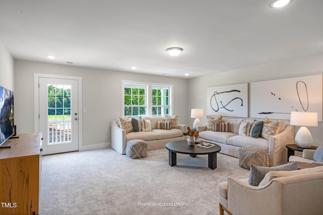 living room featuring recessed lighting, light colored carpet, and baseboards