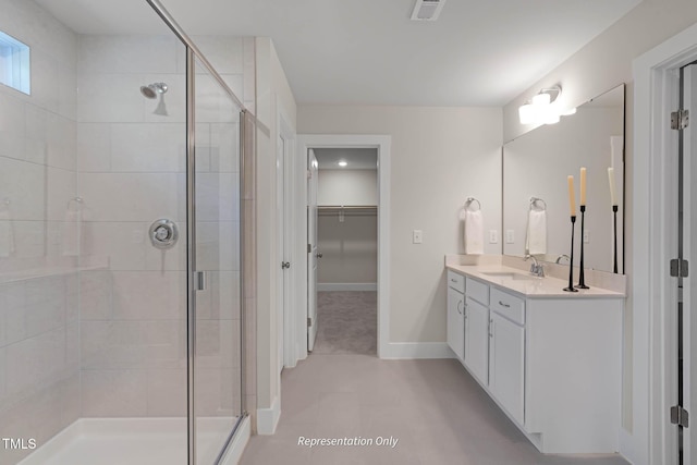 bathroom featuring walk in shower, vanity, and tile patterned flooring