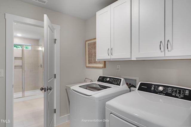 clothes washing area with cabinets and washing machine and clothes dryer