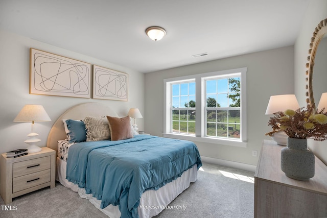 bedroom featuring light carpet, visible vents, and baseboards