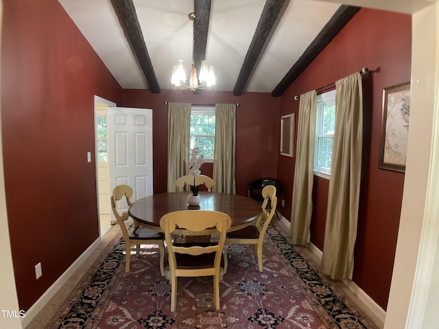 dining room featuring lofted ceiling with beams and a notable chandelier