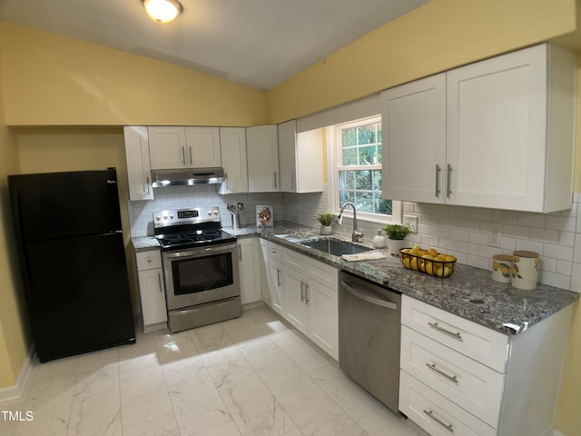 kitchen with white cabinetry, stainless steel appliances, tasteful backsplash, dark stone countertops, and vaulted ceiling