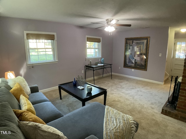 living room with ceiling fan, light carpet, and a fireplace