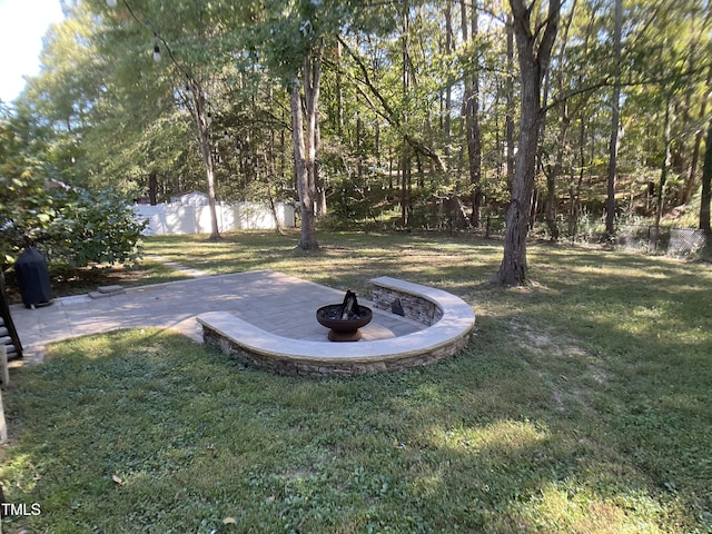 view of yard featuring an outdoor fire pit and a patio