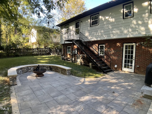 back of property featuring an outdoor fire pit, a patio area, and a yard