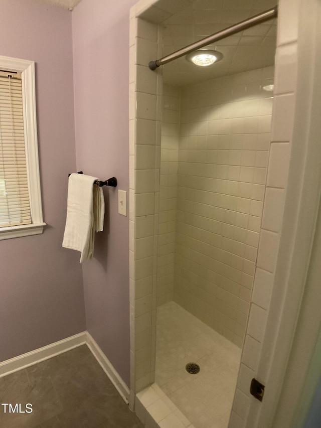 bathroom featuring tile patterned flooring and a tile shower