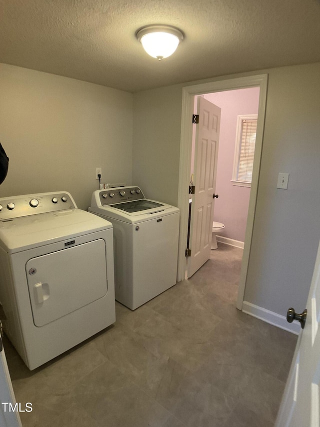 laundry room featuring a textured ceiling and separate washer and dryer