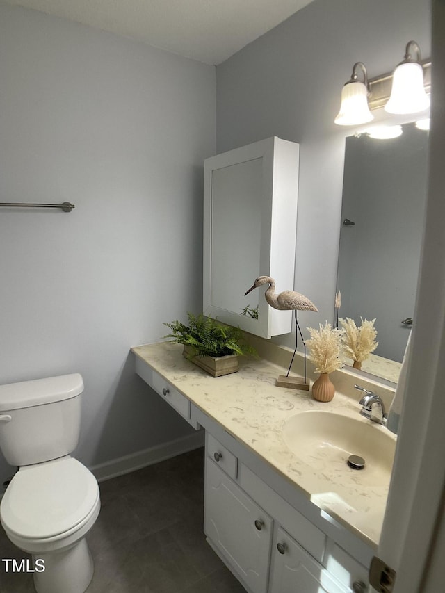 bathroom with toilet, vanity, and tile patterned floors