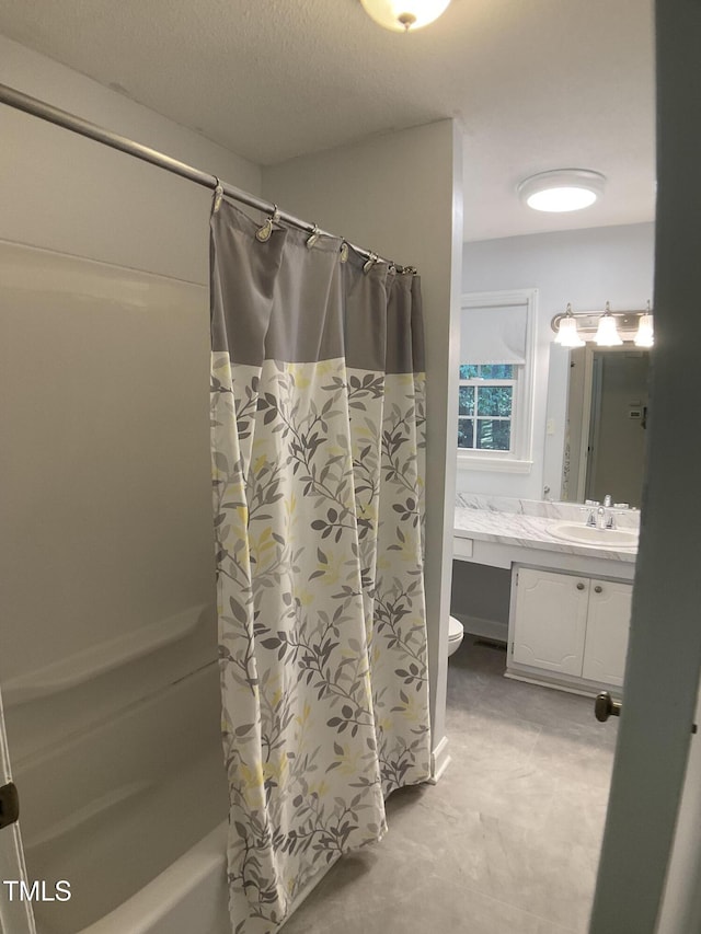 full bathroom featuring shower / bath combo with shower curtain, a textured ceiling, toilet, and vanity