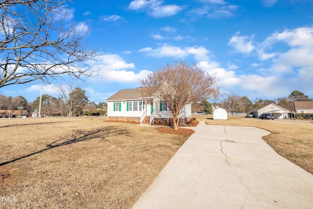 view of front of property featuring a front lawn and a shed