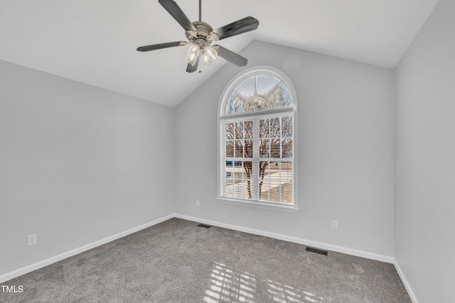 spare room with ceiling fan, a wealth of natural light, lofted ceiling, and carpet floors