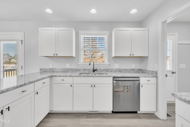 kitchen featuring light stone countertops, white cabinets, dishwasher, and sink