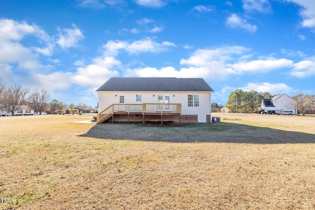 back of property featuring a wooden deck and a lawn