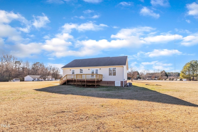 rear view of house featuring a deck and a yard