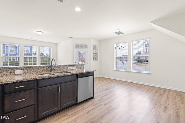 kitchen featuring dishwasher, a healthy amount of sunlight, sink, hanging light fixtures, and light stone counters