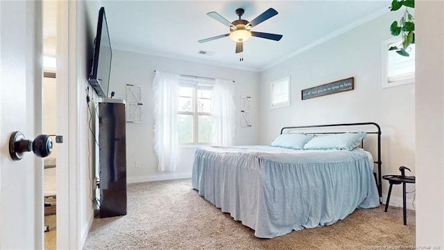 carpeted bedroom featuring ceiling fan and crown molding