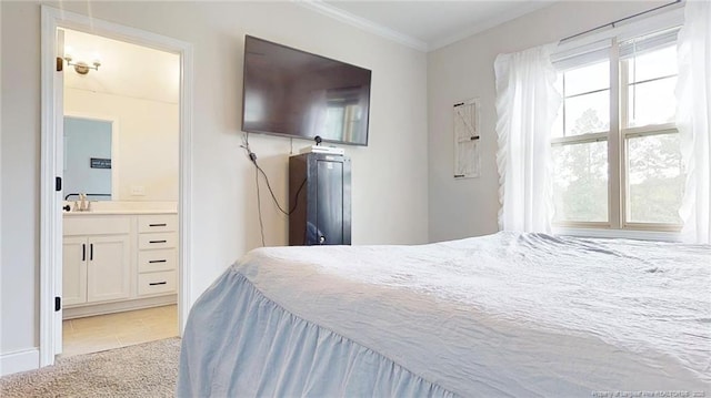 carpeted bedroom with crown molding, sink, and ensuite bath