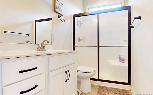 bathroom featuring vanity, toilet, and an enclosed shower