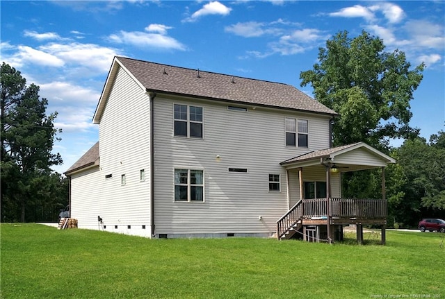 back of property with a deck and a lawn