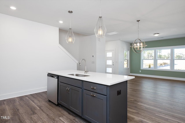 kitchen with pendant lighting, stainless steel dishwasher, an island with sink, and sink