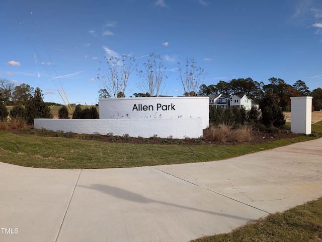 community sign featuring a lawn