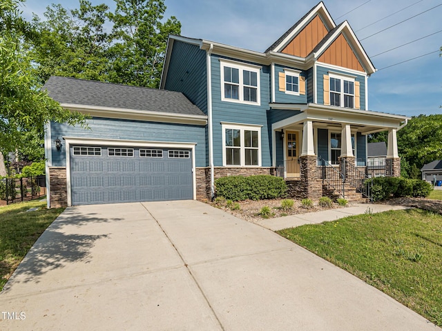 craftsman-style home with board and batten siding, stone siding, an attached garage, and concrete driveway