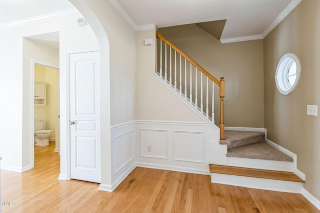 staircase with crown molding and hardwood / wood-style floors