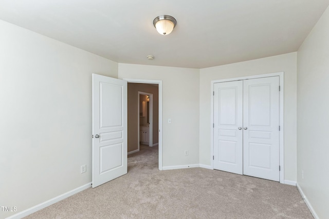 unfurnished bedroom with a closet and light carpet