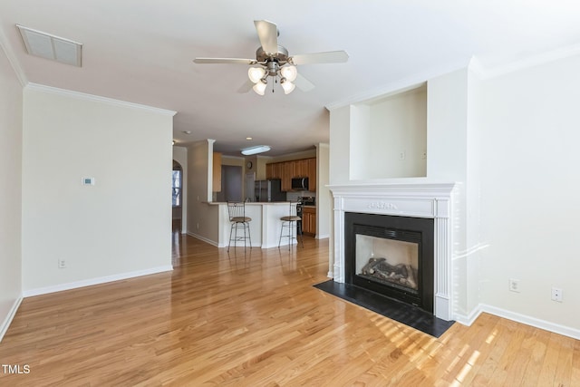 unfurnished living room with light hardwood / wood-style floors, crown molding, and ceiling fan