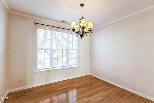 spare room with hardwood / wood-style floors, crown molding, and a notable chandelier