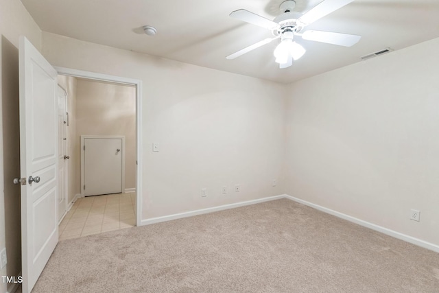 spare room featuring ceiling fan and light colored carpet