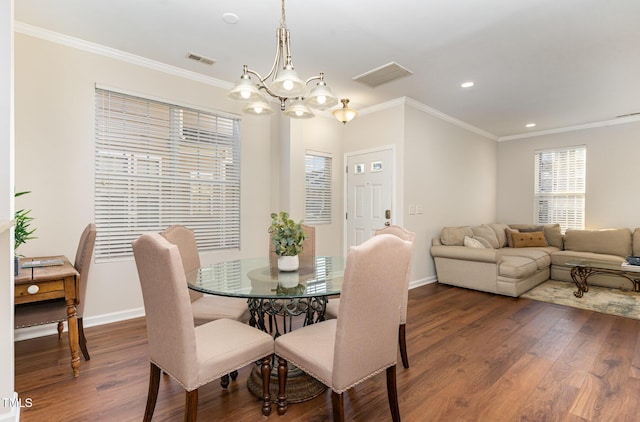 dining room with a chandelier, dark wood-type flooring, and ornamental molding