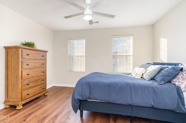 bedroom with ceiling fan, hardwood / wood-style floors, and multiple windows