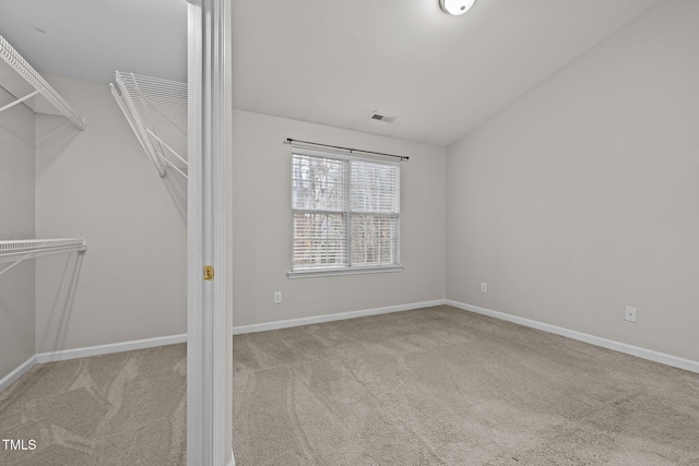 interior space with vaulted ceiling and light carpet