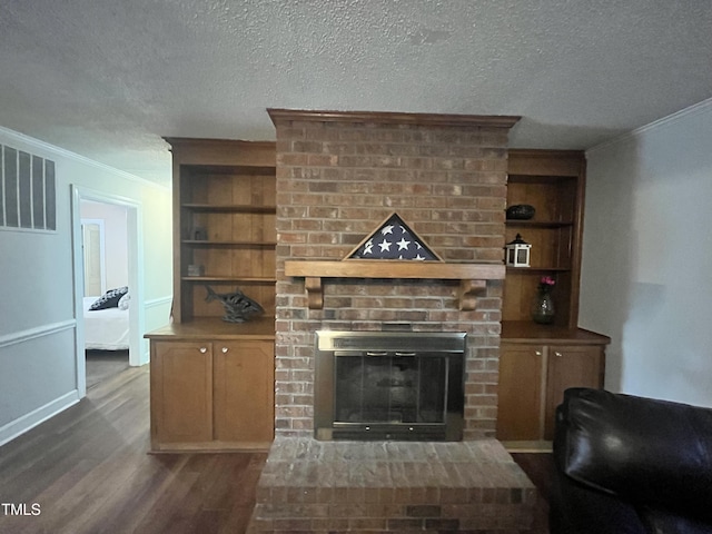 living room featuring built in shelves, a fireplace, and a textured ceiling