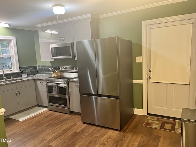 kitchen featuring gray cabinets, appliances with stainless steel finishes, wood-type flooring, dark stone counters, and sink