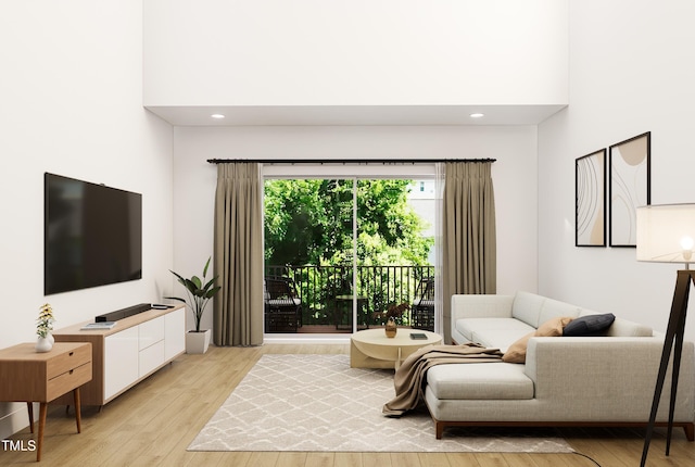 living room featuring light wood-type flooring and a towering ceiling