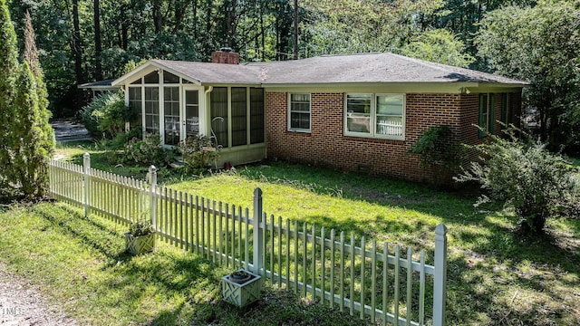 view of front of property featuring a front yard and a sunroom