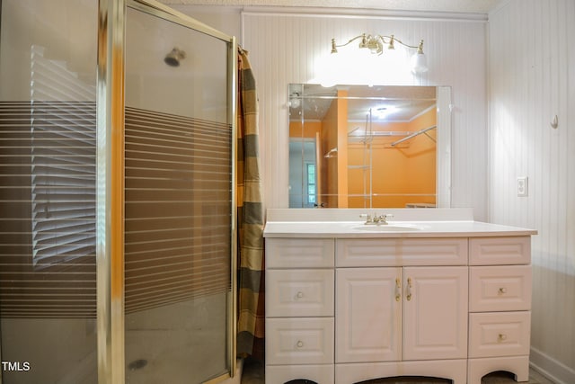 bathroom with a shower with shower door, vanity, ornamental molding, and wooden walls