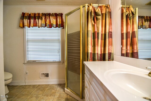 bathroom featuring toilet, vanity, tile patterned floors, a textured ceiling, and a shower with door