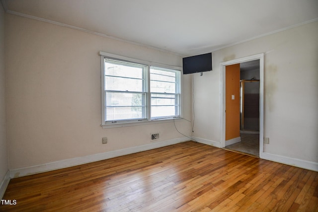 spare room with crown molding and light hardwood / wood-style floors