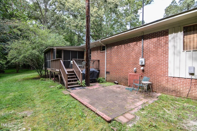 back of property with a patio area, a sunroom, and a lawn