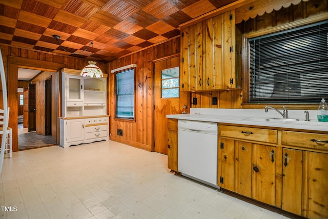 kitchen featuring pendant lighting, dishwasher, wood ceiling, sink, and wood walls