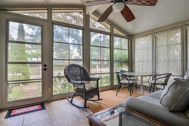 sunroom / solarium with ceiling fan, vaulted ceiling with beams, and a wealth of natural light