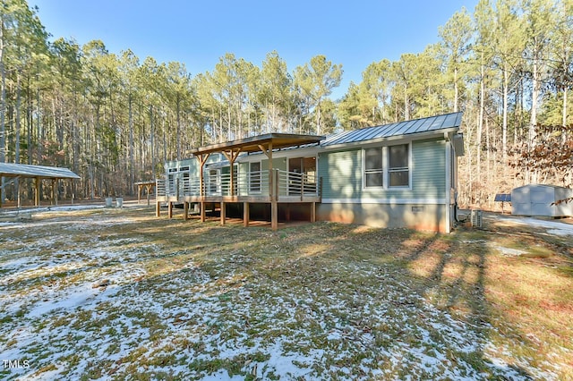 back of house with a wooden deck and a storage unit