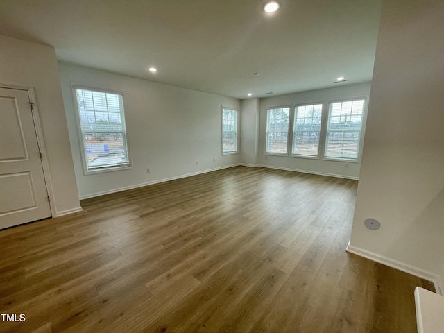 unfurnished room with hardwood / wood-style flooring and plenty of natural light