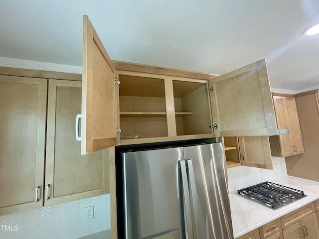 interior space with tasteful backsplash, light brown cabinets, and stainless steel appliances